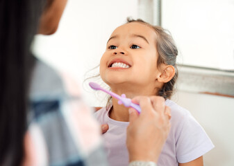 Sticker - Look at how theyre shining. Shot of a mother helping her little daughter brush her teeth in the bathroom at home.