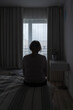© troyanphoto - Mature woman sitting alone in the room, sad depressed person. Back view. mental health