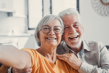 Wall Mural - Head shot portrait happy senior couple taking selfie, having fun with phone cam, smiling aged wife and husband hugging, looking at camera, posing for photo, aged man vlogger recording video.