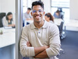 © Michael C/peopleimages.com - Ready for business. Shot of a young businessman standing with his arms crossed in an office at work.