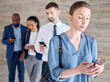 © Michael C/peopleimages.com - I can network on social media too. Shot of a mature businesswoman using a phone while waiting in line at an office.