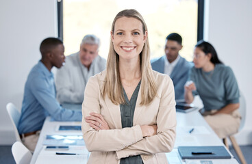 Poster - Self-assurance reassures others. Portrait of a confident businesswoman standing with her arms crossed in an office while her colleagues have a meeting in the background.