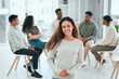 © K Abrahams/peopleimages.com - I wouldnt be here without my support group. Shot of an attractive young woman standing while her support group talk behind her.