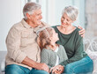 © Nina L/peopleimages.com - Little girl looking up at her grandmother while sitting together at home. Cute girl bonding with her grandmother and grandfather. Loving grandparents spending time with their granddaughter