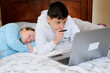 © Oleksandra - teenagers sit at computers do homework online study and are not tired of studying go to bed fall asleep One works the other sleeps no desire to study eyes hurt need to rest