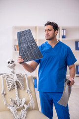 Wall Mural - Young male doctor radiologist and skeleton patient at the hospit