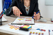 © RomanR - Single smiling business woman wear suit work with paper chart documents at office