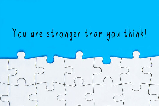 You Are Stronger Than You Think text with Jigsaw Puzzle on Blue Background