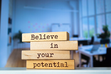 Wall Mural - Wooden blocks with words 'Believe in your potential'.