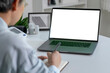 © amenic181 - Video call. Asian patient woman using laptop with blank white screen at home.