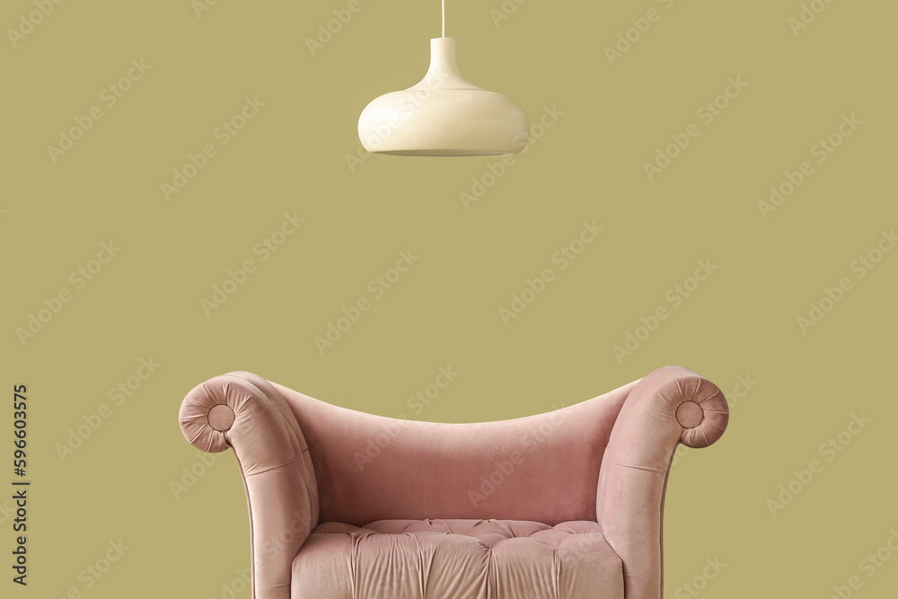 Stylish sofa and lamp on green background