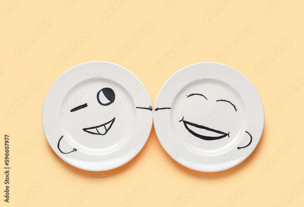 Plates with happy faces for Friendship Day on beige background