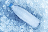 Fototapeta Kawa jest smaczna - Cold bottle of water over ice cubes. Food and drink background.