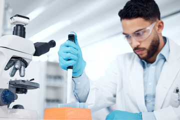 Aufkleber - One mixed race male scientists wearing safety goggles and a labcoat while conducting medical research experiments with pipette and test tubes in a lab. Recording his findings for future investigation