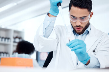 Aufkleber - One mixed race male scientist wearing safety goggles and a labcoat while conducting a medical research experiment with pipette and test tubes in a lab. Recording his findings for future investigation