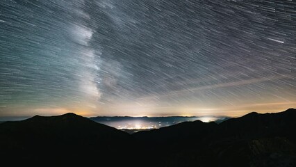 Wall Mural - startrails of milky way galaxy in starry night sky in mountains astronomy time lapse, star trails ov