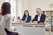 © Studio Romantic - Young woman is being interviewed by two friendly, smiling business partners, colleagues are listening to potential new employee. Three people at meeting in office. Candidate for position in company.