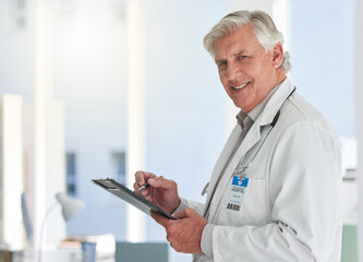 Poster - I know all your symptoms. Shot of a mature doctor writing on a form at a hospital.
