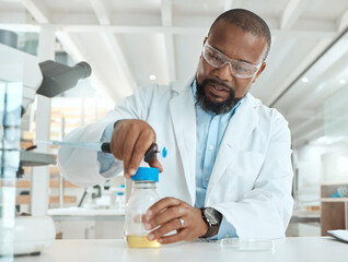 Poster - Lets see whats causing the infection. Shot of a handsome mature scientist sitting alone in his laboratory and opening a bottle of liquid for testing.