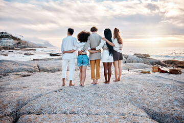 Canvas Print - Rear view of a Unknown group of friends enjoying their time together at the beach. Diverse group of friends huddling outdoors