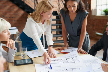 Aufkleber - We need this completed first before we proceed. Shot of a group of architects working with blueprints in an office.