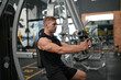 © FotoArtist - Man doing weight lifting exercises inside the gym