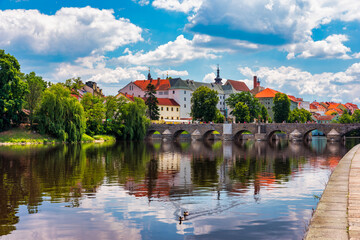 Wall Mural - Medieval Town Pisek and historic stone bridge over river Otava in the Southern Bohemia, Czech Republic. Pisek Stone Bridge, the oldest preserved early Gothic bridge in the Czech republic.