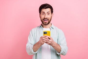 Photo of young funny excited man hold smartphone unexpected shopping black friday advert proposition isolated on pink color background