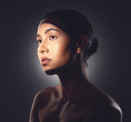 Canvas Print - Its important to make a conscious effort to look after your skin. Studio shot of a beautiful young woman posing with light beam against her face.