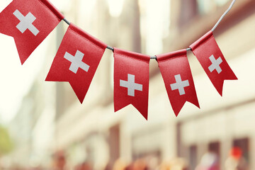 Wall Mural - A garland of Switzerland national flags on an abstract blurred background