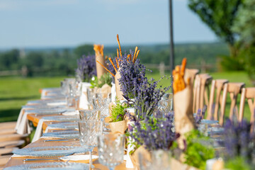Wall Mural - Beautiful outdoor celebration table green background with lavender decoration