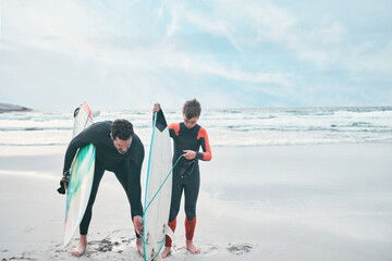 Sticker - Learning to surf with dad. Shot of a man and his young son at the beach with their surfboards.