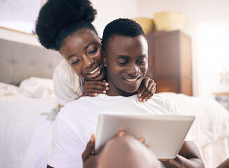 Canvas Print - Lets take a look. Shot of a young couple using a digital tablet together at home.