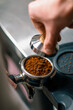 © Guys Who Shoot - A professional barista in a coffee shop prepares ground coffee by tamping fresh ground coffee beans close-up