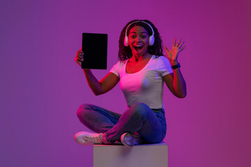 Poster - Excited Black Female Holding Blank Digital Tablet In Neon Light