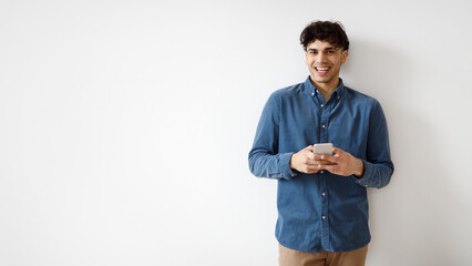 Poster - Arabic Guy Using Smartphone Surfing Social Media Near White Wall