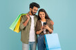 © Prostock-studio - Loving indian couple using nice shopping mobile app, copy space