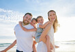© D Fernandes/peopleimages.com - Happy family at the beach. Portrait of smiling young parents with children having fun on vacation. Little boy and girl enjoying summer with mother and father