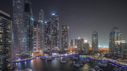 Poster - Panorama showing Dubai marina tallest skyscrapers and yachts in harbor aerial night timelapse.