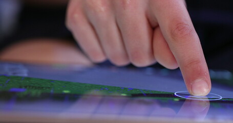 Wall Mural - Kid finger touching screen playing game on tablet. Closeup of child hand using device