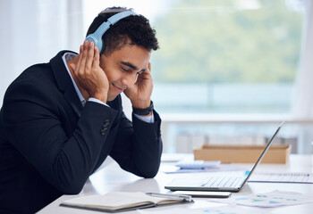 Aufkleber - Getting lost in the music as he works. Shot of a young businessman wearing headphones while working in an office.