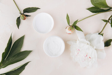 a cream mask on a light background with a delicate peony flower. mock up image.