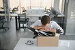 © Serhii - Sad Fired. Let Go Office Worker Packs His Belongings into Cardboard Box and Leaves Office. Workforce Reduction, Downsizing, Reorganization, Restructuring, Outsourcing. Mass Unemployment Market Crisis