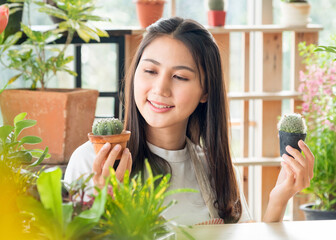 Wall Mural - Portrait Beautiful pretty young Asian girl woman wearing white blouse with long black hair and beautiful, smiling with bright smile and looking small tree In tree planting room Happily and relaxed