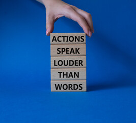 Wall Mural - Actions speak louder than Words symbol. Wooden blocks with words Actions speak louder than Words. Beautiful blue background. Businessman hand. Business and Actions concept. Copy space.