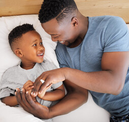 Wall Mural - Are you ready to have lots of fun with me today. High angle shot of a father and his son relaxing together in bed at home.