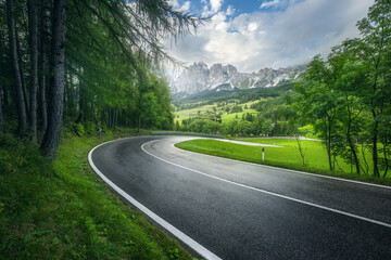 Wall Mural - road in green forest in rainy summer day. dolomites, italy. beautiful mountain roadway, tress, grass