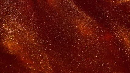 Wall Mural - Falling jets of gold particles in red liquid. Gold dust particles floating and flying apart in red fluid. Beautiful shiny moving background.