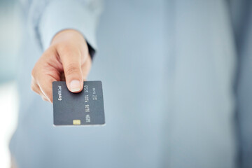 Wall Mural - The easiest way to pay. Cropped shot of an unrecognizable businesswoman holding out her credit card while standing in the office.