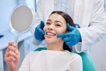 Poster - The brightest smile in the room. Shot of a young woman checking her results in the dentists office.